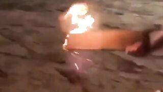 WCGW putting a flaming piece of wood into a mysterious conta
