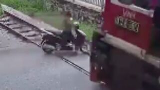 Scooter rider is swept by a train in Vietnam