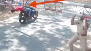 Biker is clotheslined by barrier after failing to stop at police crossing in India