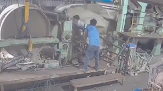 Worker is rolled up by roller press machine inside factory in India