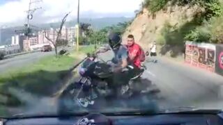 Biker attempts a 180° turn on a busy road but gets hit by a Bus