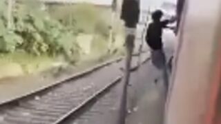 Man showing off killed hanging off the side of a train and getting clipped by a post