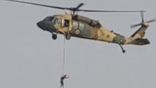 Man strope harnessed to a helicopter over afganistan