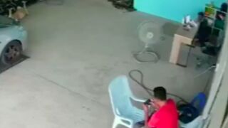 Mechanic gets taken out by a runaway tyre while on his phone