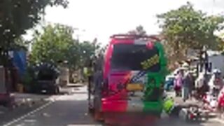 Police try and pull a bus over but gets knocked off his bike instead