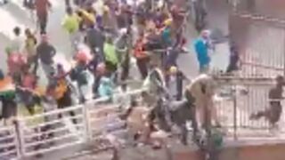 Police officers get chased down and beaten with sticks by rioters in India