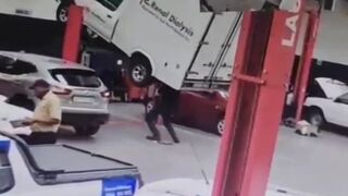 Unbalanced van falls from a car lift injuring mechanic