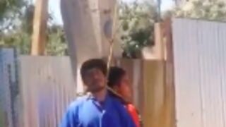 Two thiefs get tied to a post with a rope around their neck for stealing bed sheets from a home in Mexico