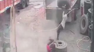 Yikes: Man gets knocked down to the ground after getting hit on the head by an exploding tyre