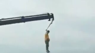 Man gets lynched from a Crane of the side of a bridge!