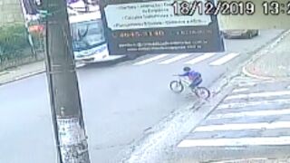 Kid ignores a junctions and rides straight underneath a bus!