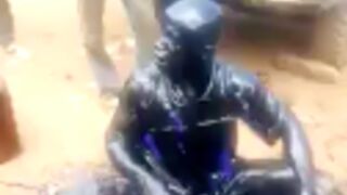 Thief gets covered in oil and beaten by villagers somewhere in africa ????