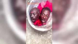 Two men's severed heads in a basin