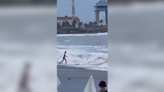 Woman gets swept out to sea as her boyfriend frantically tries to help save her in Sochi, Russia.