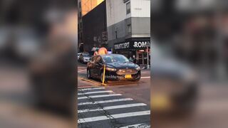 Lawless NYC: A half-naked man stands on top of a vehicle while two NYPD female officers sit inside