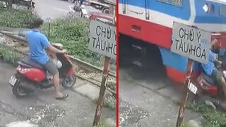 Distracted motorcyclist is killed and dragged after getting hit by a train - Hanoi, Vietnam