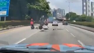 Runaway tire smashes into motorcycle and sends rider flying in middle of road - Malaysia