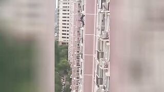 One man falls out of a window from a great height. Video.