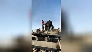 Hamas militants mock the body of an Israeli tank crewman