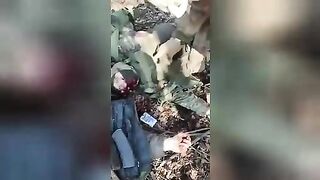 Ukrainian soldiers rob the corpses of Russian soldiers